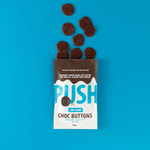Push Chocolate Low Sugar Original Chocolate Buttons pictured on a blue backdrop with dairy-free chocolate buttons coming out the top of the packaging.