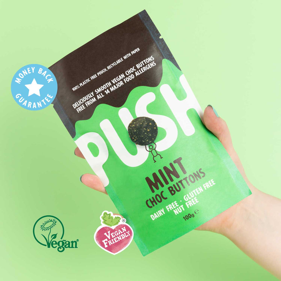 Holding a pouch of mint dairy free chocolate buttons with vegan certification